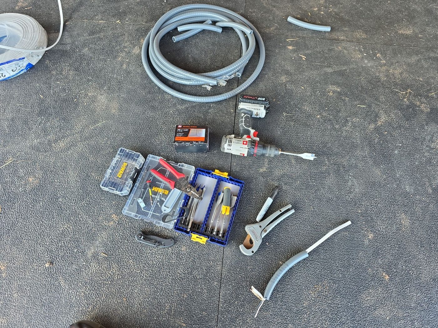Electrical tools, wire, and conduit laid out for a diagnostic job